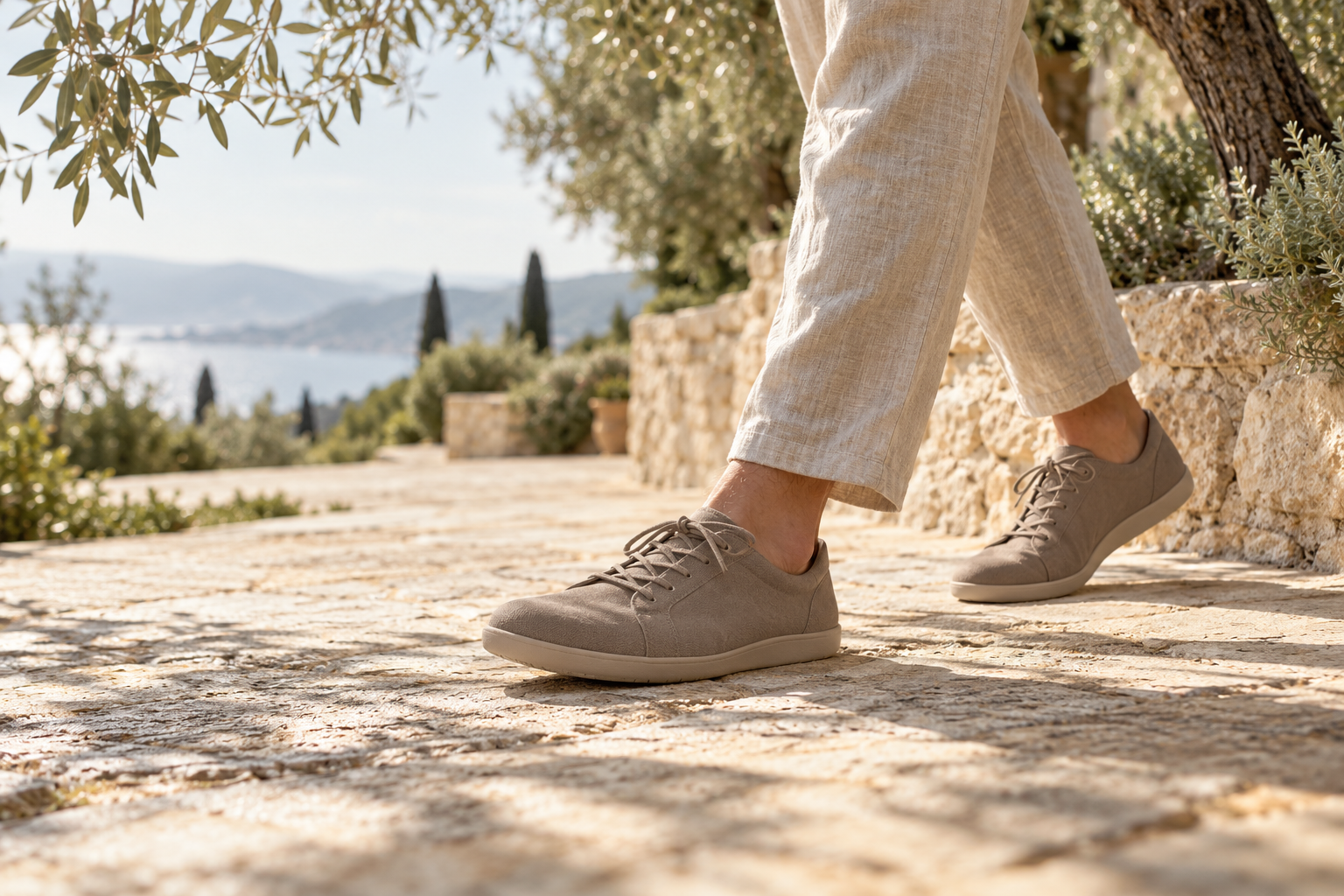 Editorial scene of minimalist footwear on a sunlit stone path
